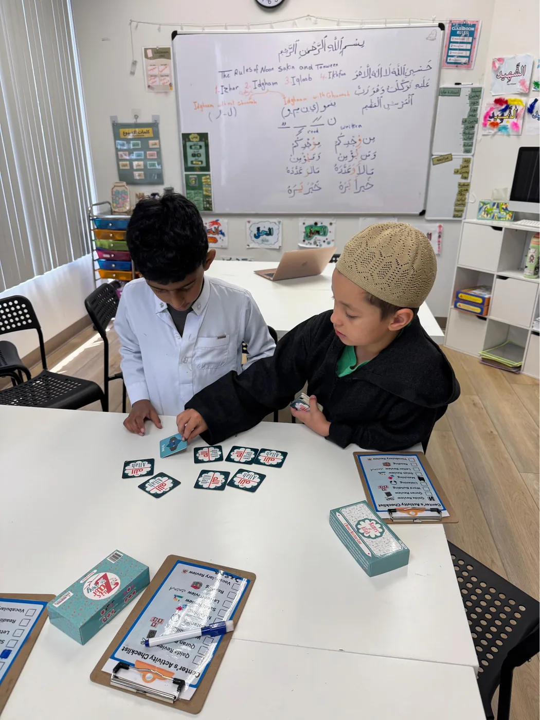 Two students at Ayat Academy reviewing names of Allah together during a classroom activity