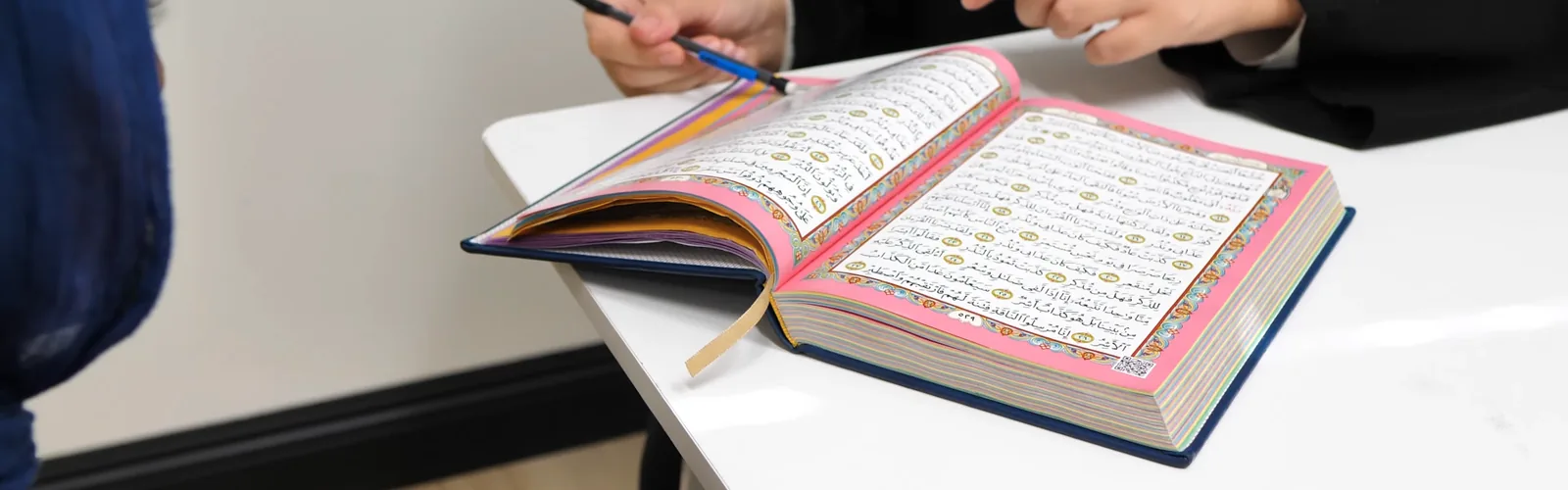 A Hifdh student working through a page of the mushaf with their teacher